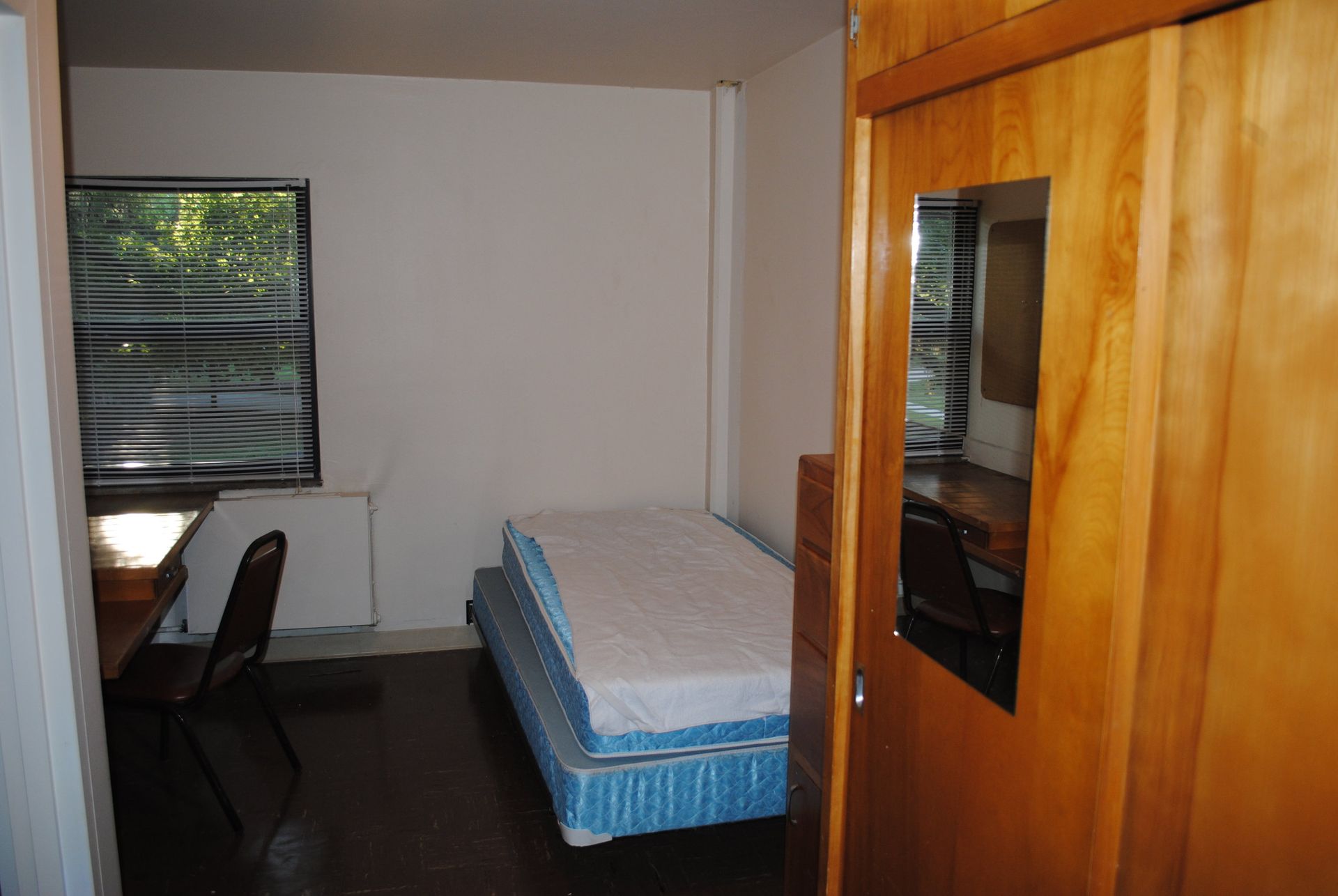 A bedroom with a mattress on the floor and a window