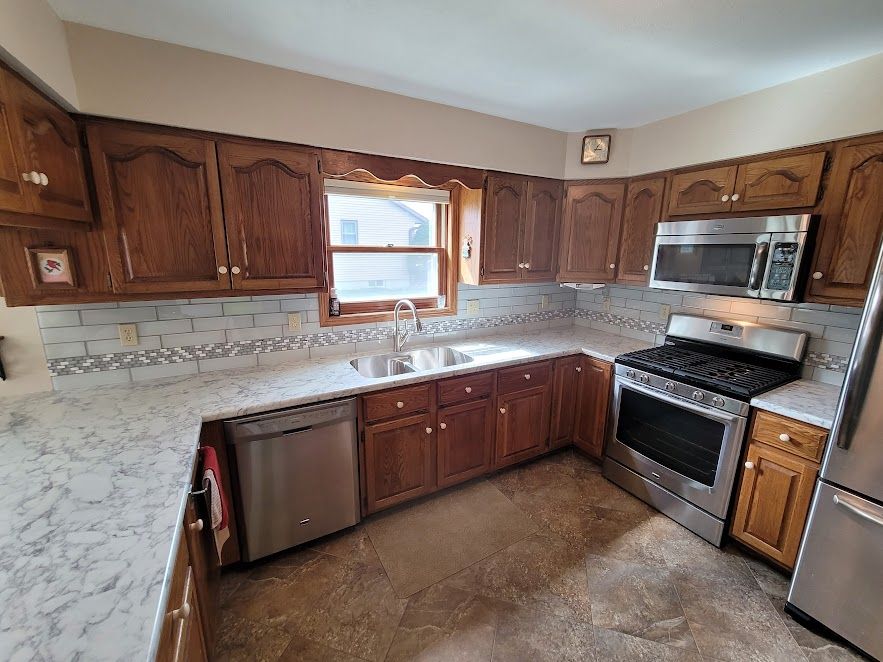 A kitchen with stainless steel appliances and wooden cabinets.