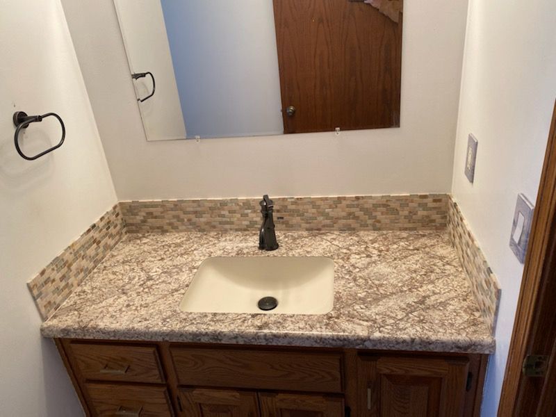 A bathroom with a sink and a mirror.