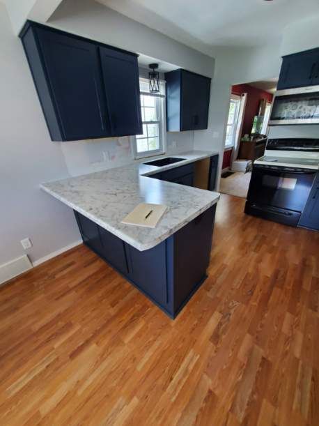 A kitchen with blue cabinets and white counter tops