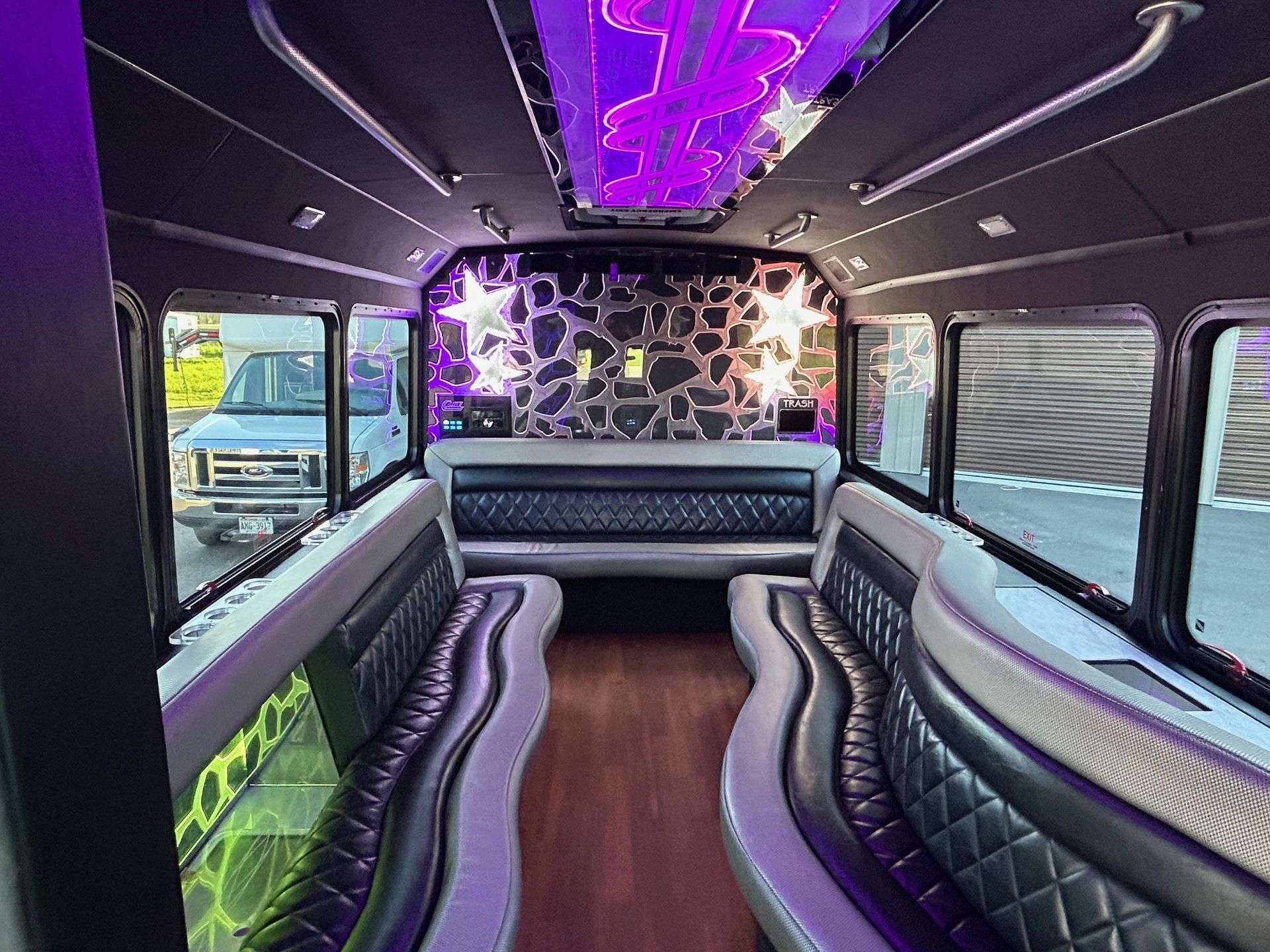 The inside of a limousine with purple lights on the ceiling.