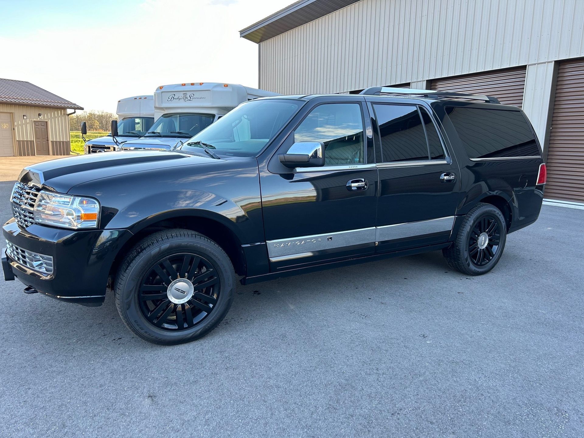 A black ford expedition is parked in front of a building.