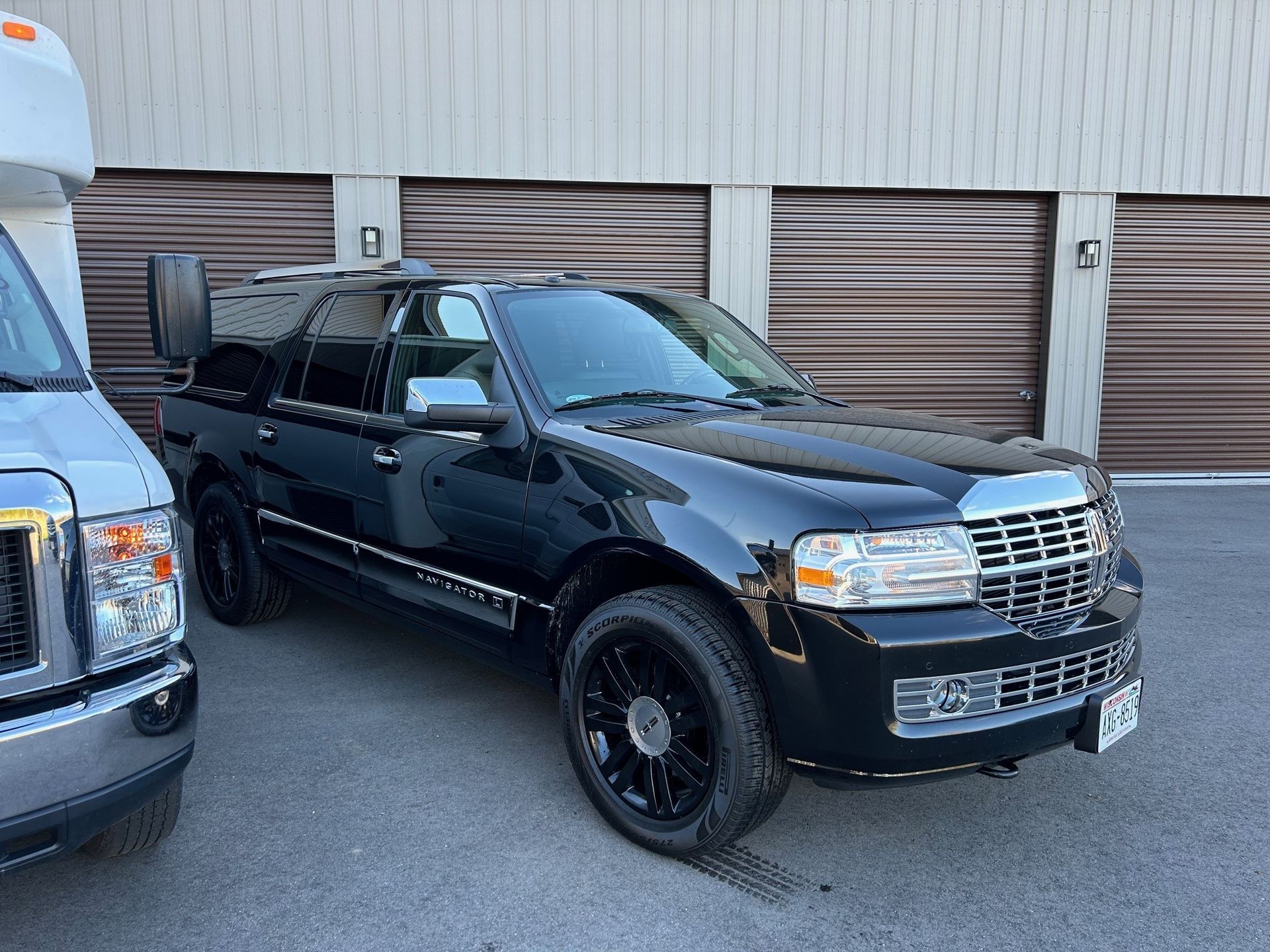 A black Navigator is parked in front of a parking lot.