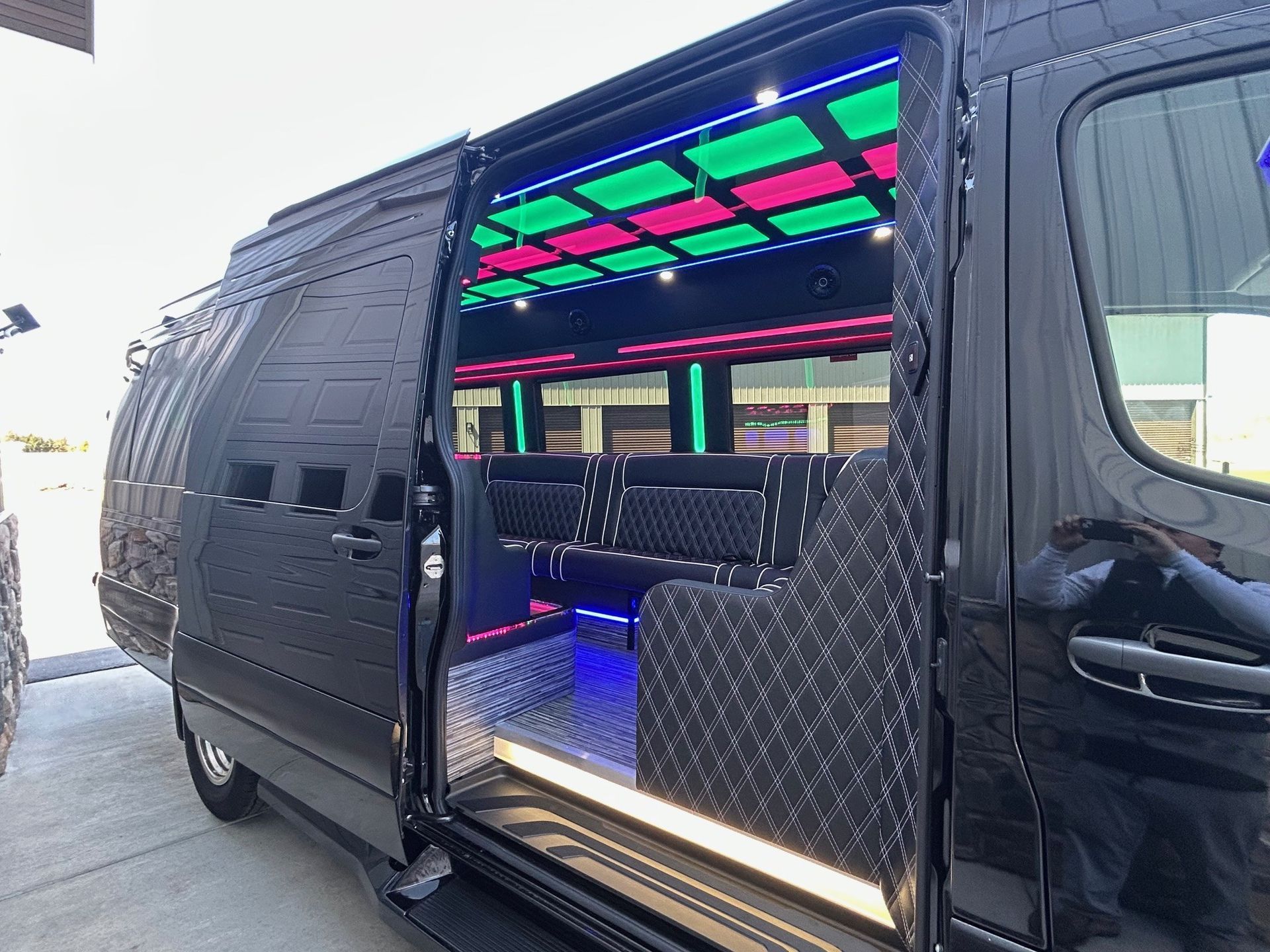 A black van with the door open and lights on the ceiling.