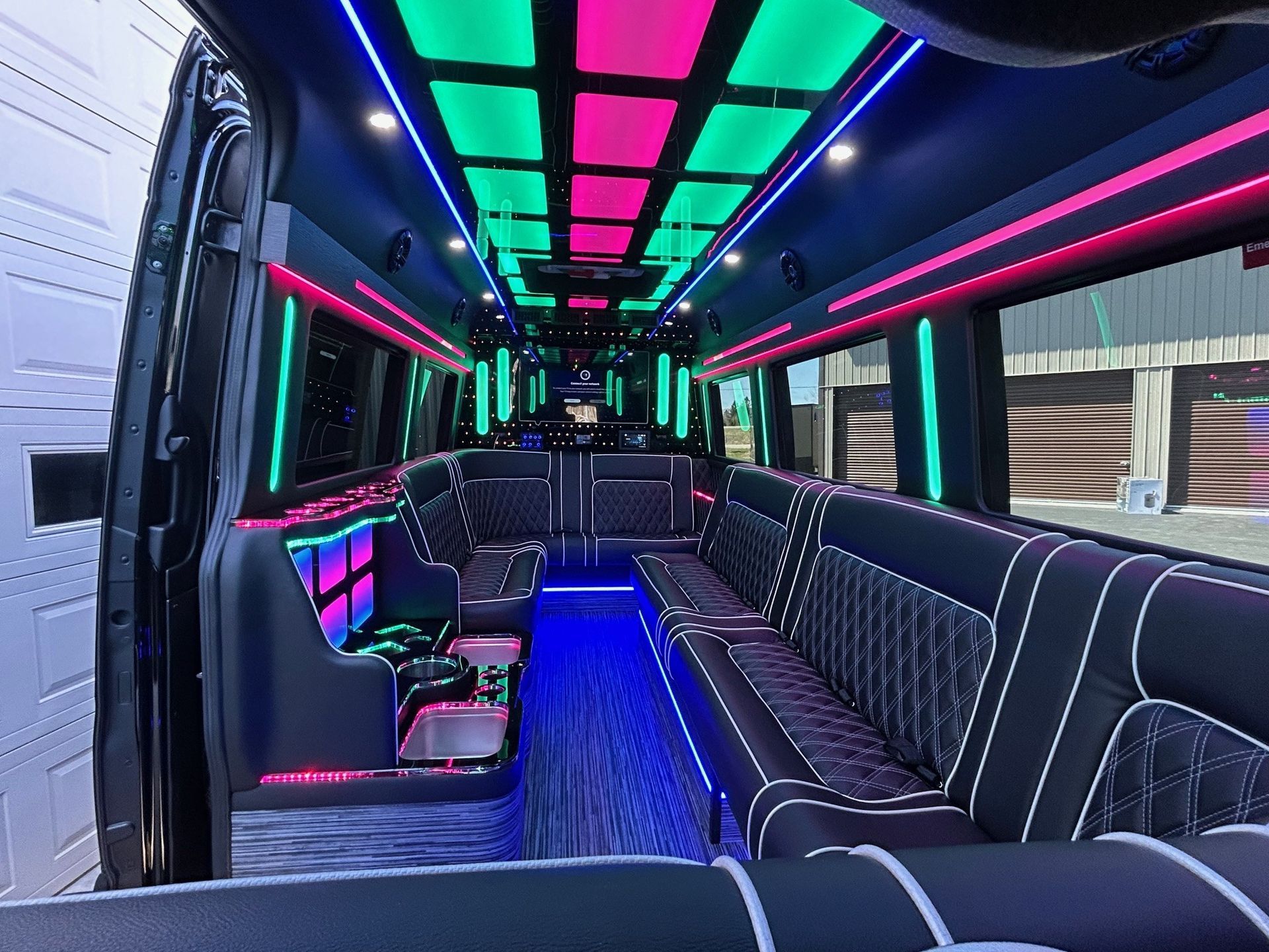 The inside of a limousine with colorful lights on the ceiling.