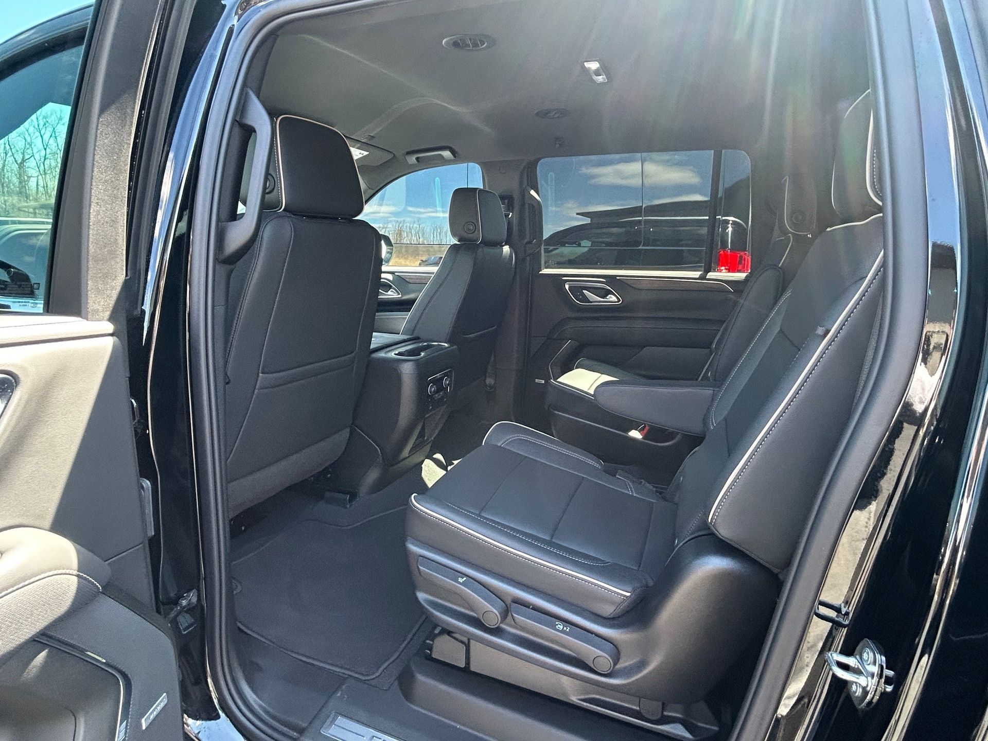 Interior of a vehicle featuring black leather bucket seats, gray carpet, and dark interior trim.