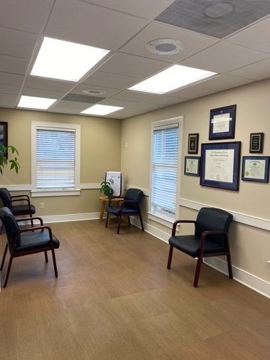 A waiting room with two chairs and a painting on the wall.