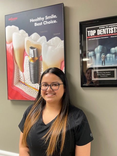 A woman is standing in front of a poster that says healthy smile best choice