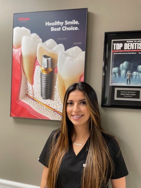 A woman is standing in front of a poster that says healthy smile best choice.