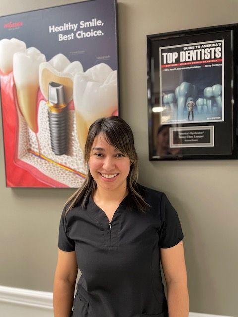 A woman is standing in front of a poster that says healthy smile best choice.