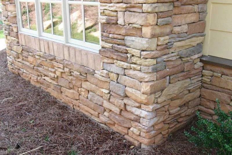 Stone veneer siding on a building's exterior. The stones are light brown and tan.