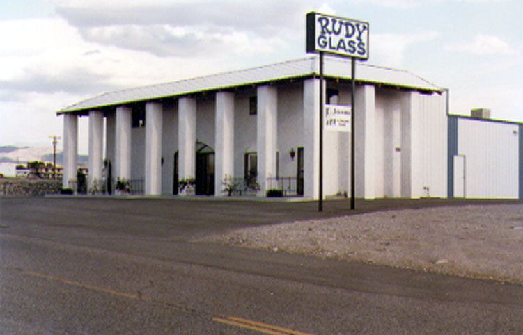 A building with columns and a sign that says rudy glass