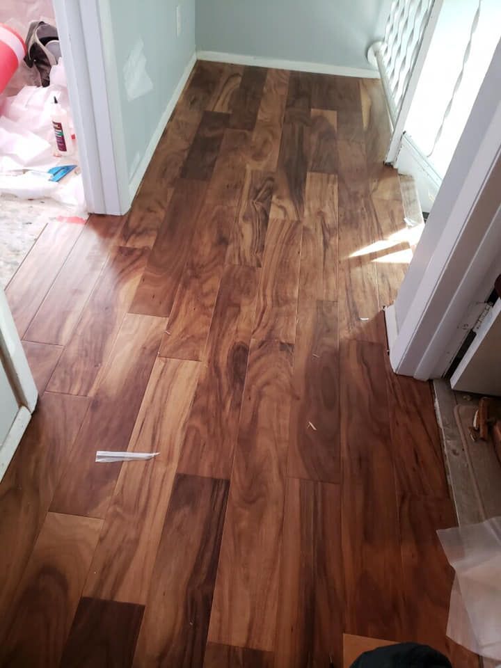 Wood-look laminate flooring in a doorway. Brown and tan planks. Natural light.