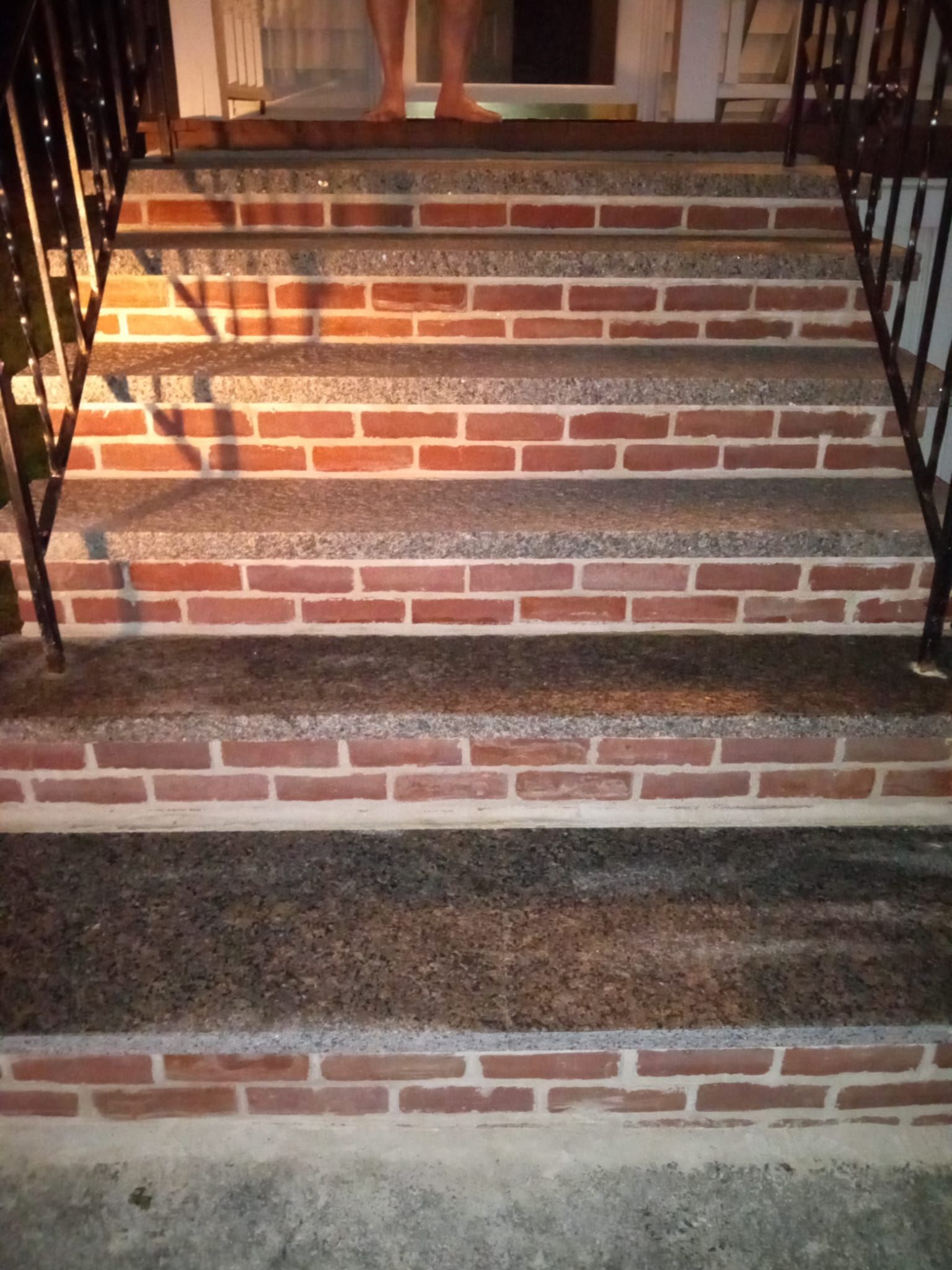 Brick steps leading to a doorway. A person stands at the top.