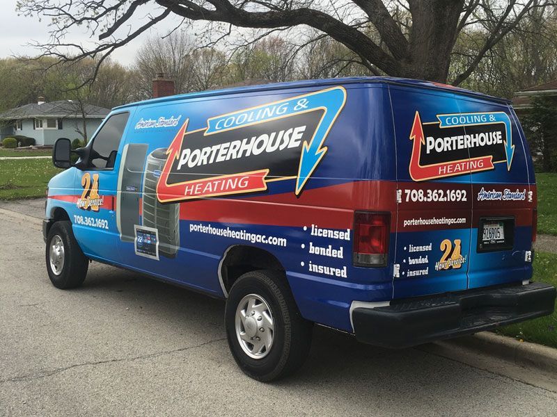Blue Porterhouse Heating service van parked on a residential street with large red and white branding.