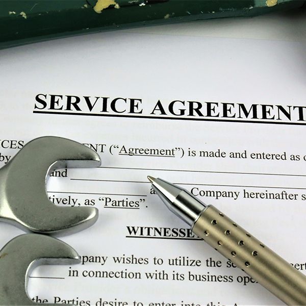 Service agreement document with pen and magnifying glass on top