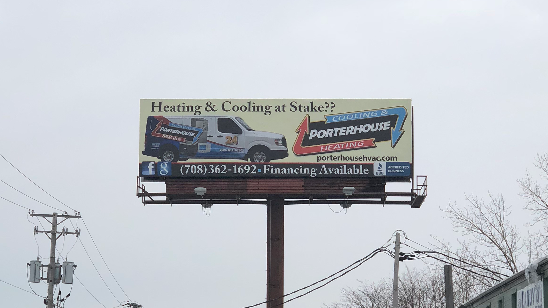 Billboard advertising heating and cooling services above a snowy roadside
