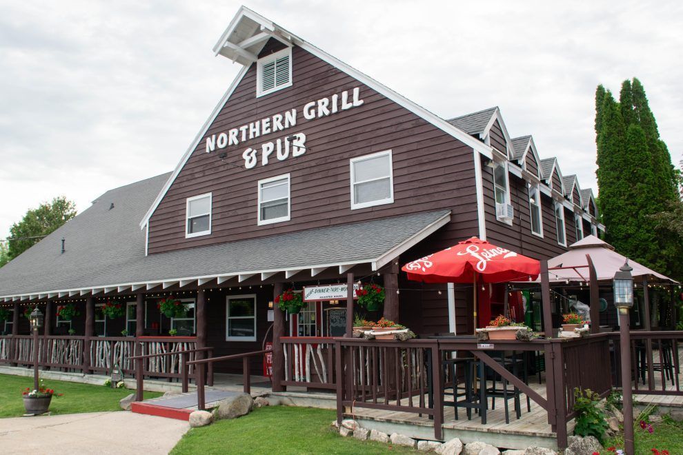 Northern Grill & Pub building with red umbrellas and outdoor patio seating