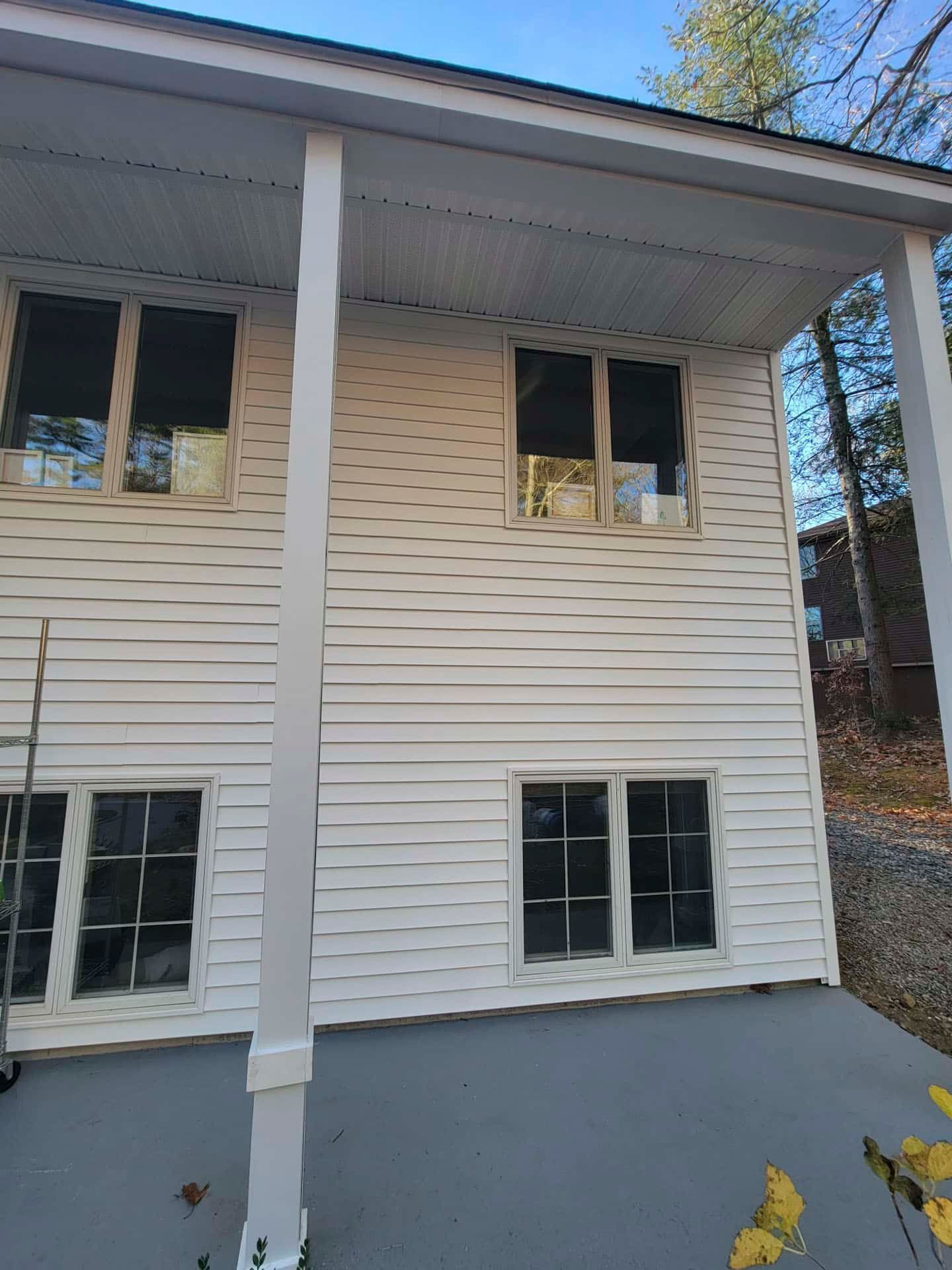White house exterior with two windows on each level and a central support post under the roof overhang