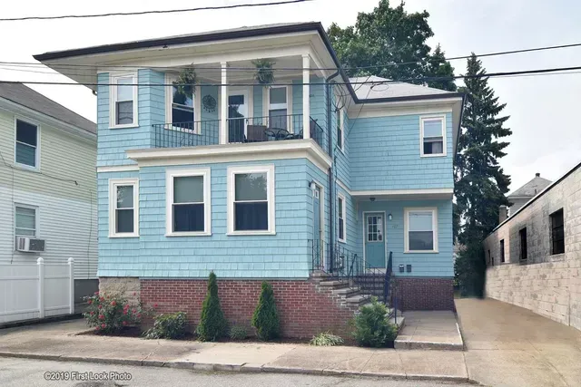 A blue house with a white porch and stairs
