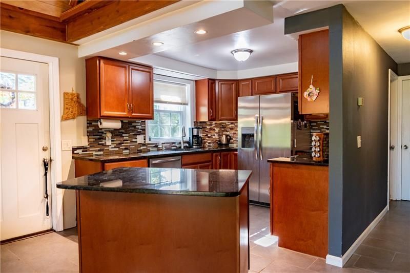 Kitchen with dark wood cabinets, granite countertops, and stainless steel appliances.
