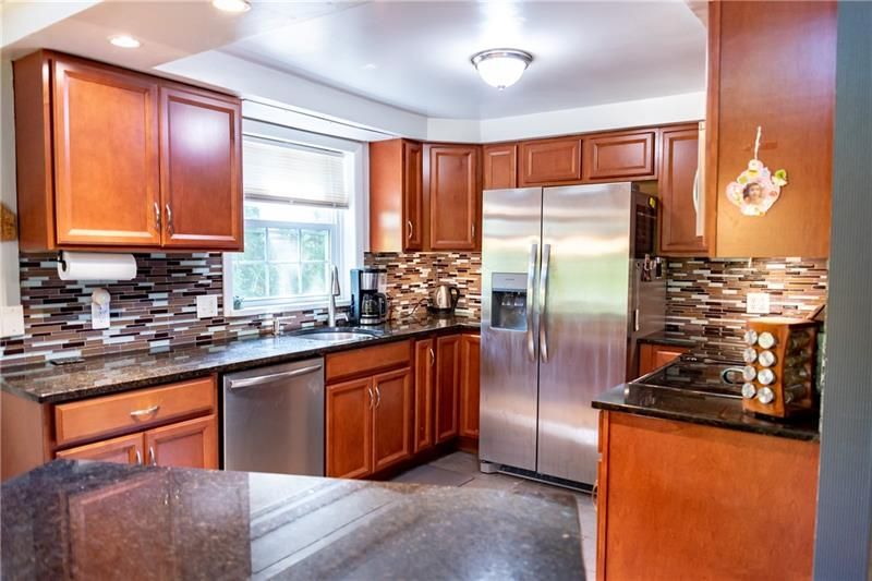 Kitchen with wood cabinets, stainless steel appliances, and dark countertops.