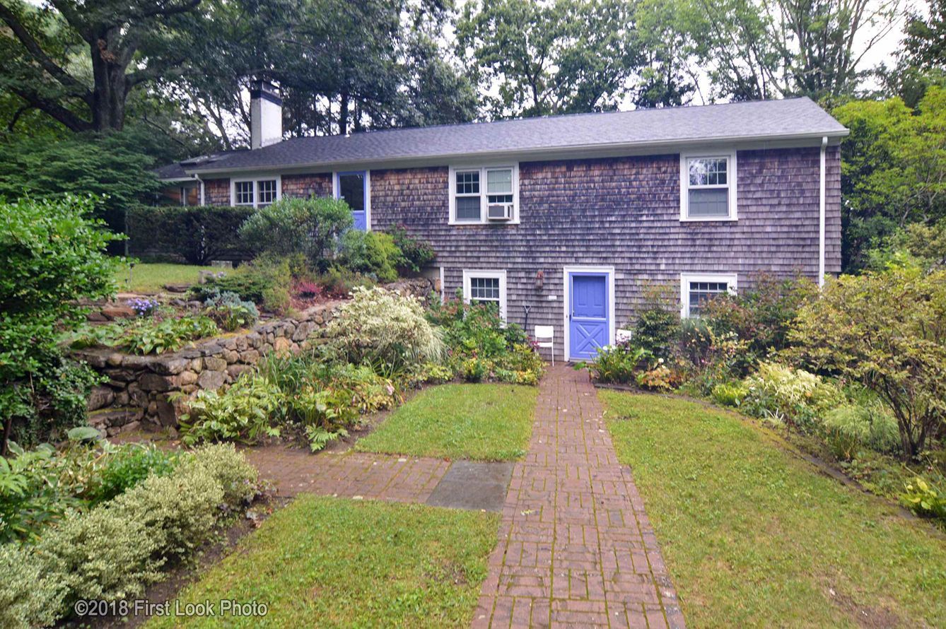 A large house with a blue door and a brick walkway leading to it