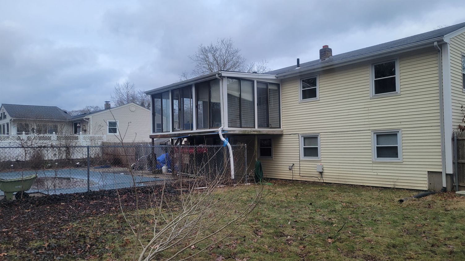 A house with a screened in porch and a pool in the backyard