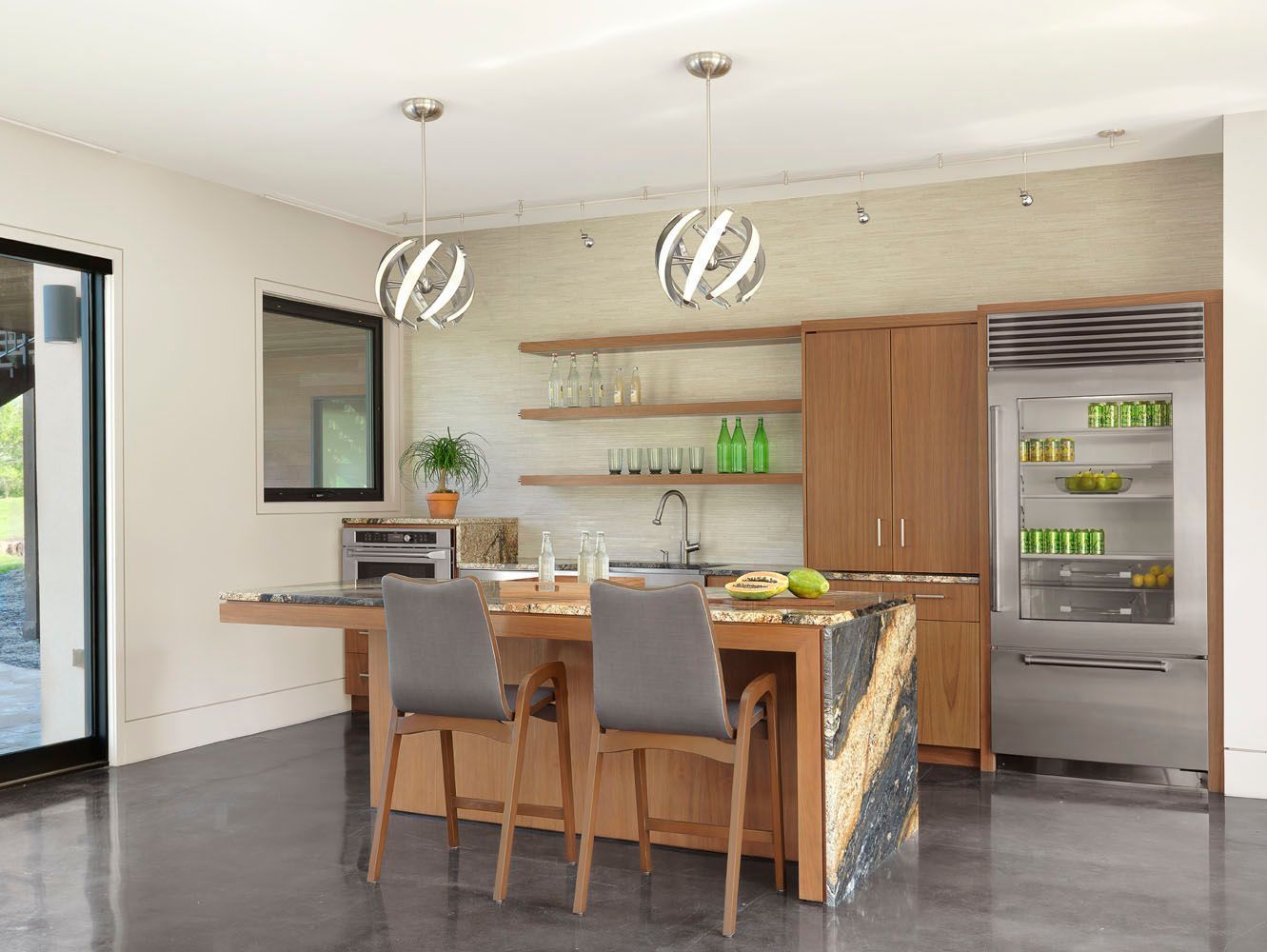 Modern kitchen with island, pendant lights, bar stools, and stainless steel appliances