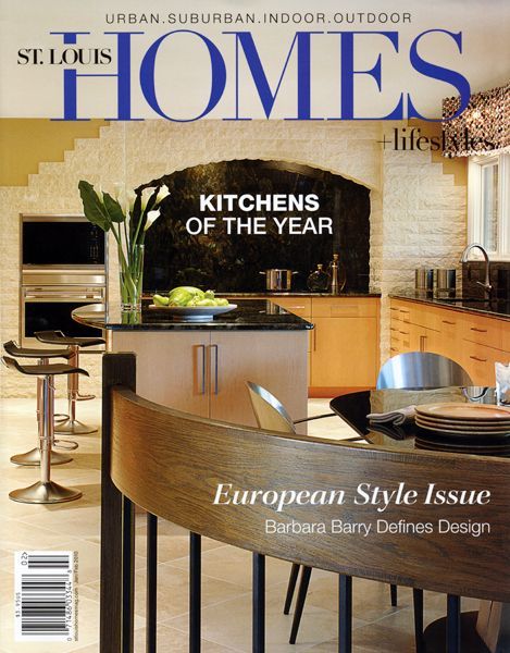 Cover of St. Louis Homes magazine featuring a modern kitchen with natural stone walls, wood cabinets, and bar stools.