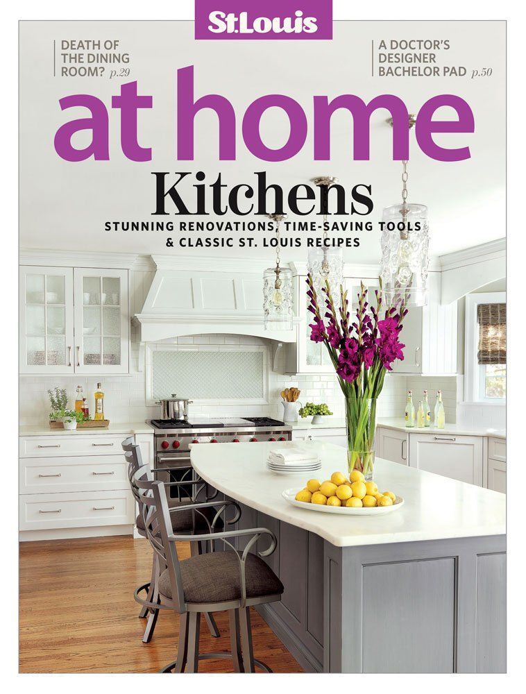 Magazine cover titled St. Louis at home, featuring a bright, modern kitchen with a white island and purple flowers.