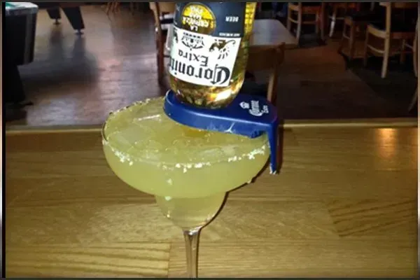 A margarita with a bottle of corona on top of it
