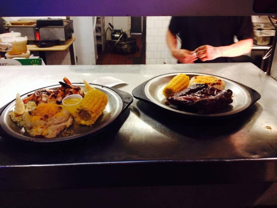 Two plates of food on a counter with a man in the background
