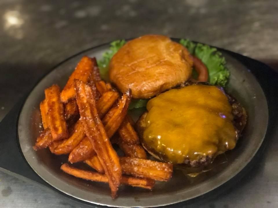 A plate of food with a hamburger and sweet potato fries