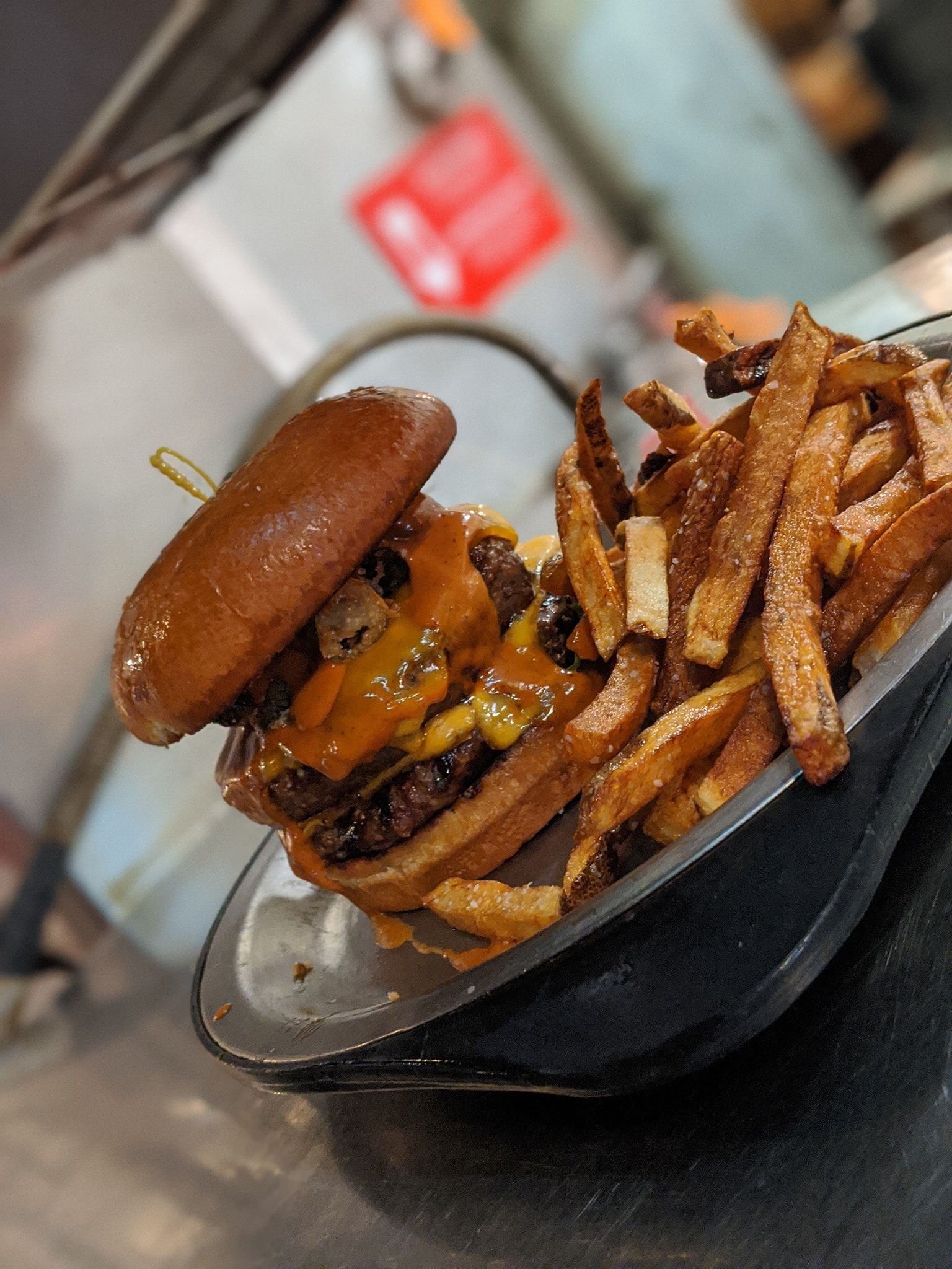 A hamburger and french fries on a plate on a table.