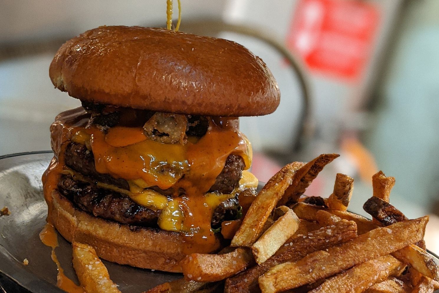 A close up of a hamburger and french fries on a plate