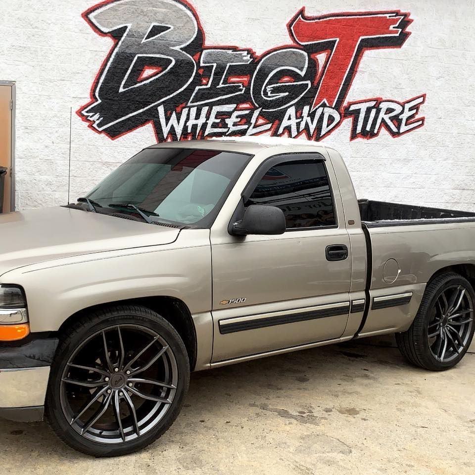 Tan pickup truck with aftermarket gray wheels in front of