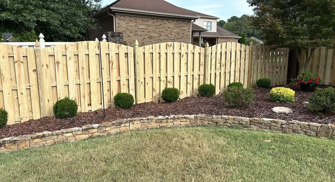 Wooden fence with landscaping and lawn.