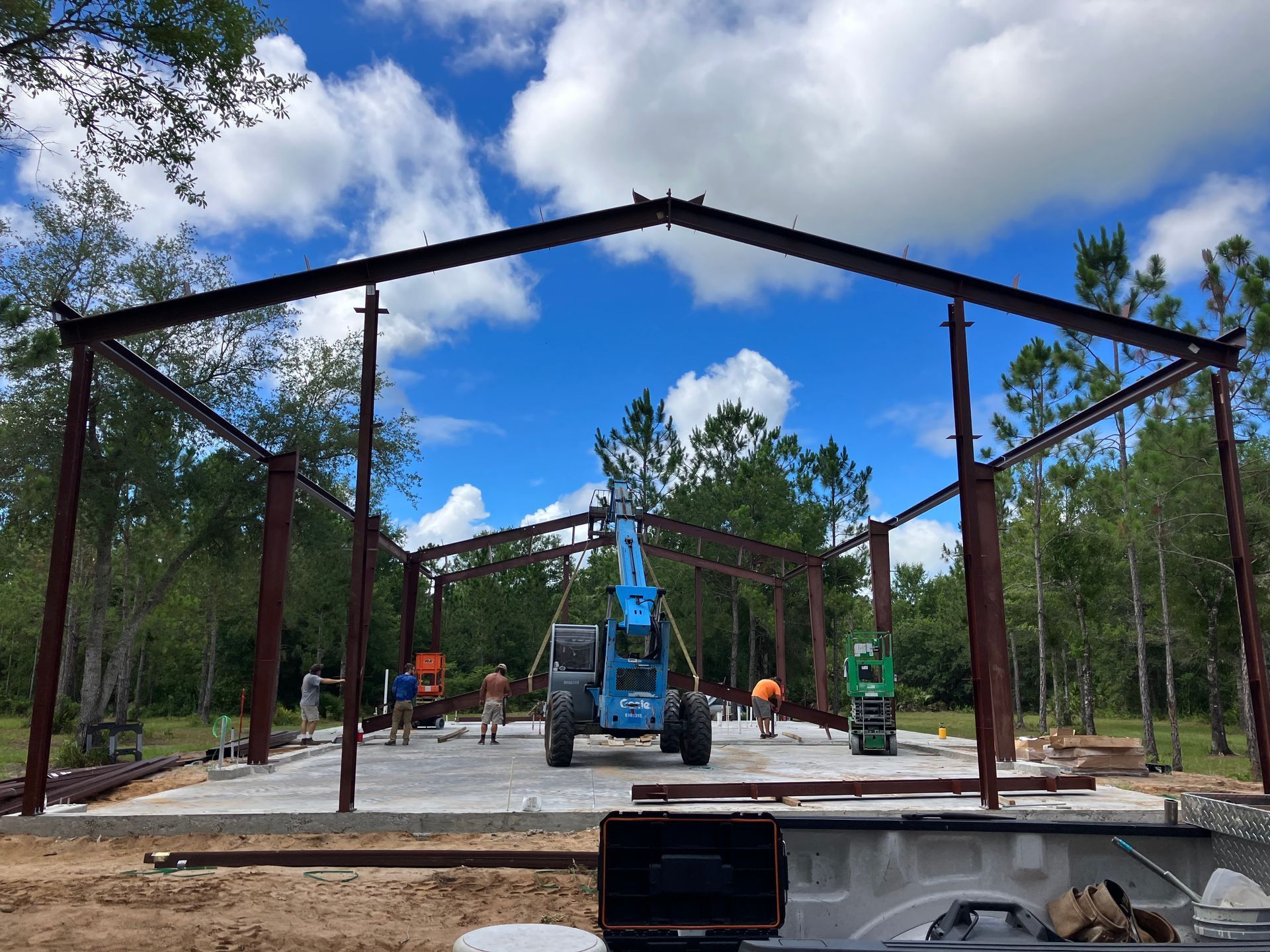 A large metal structure is being built in the middle of a field.