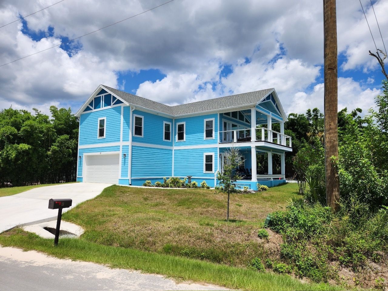 A blue and white house with a mailbox in front of it.