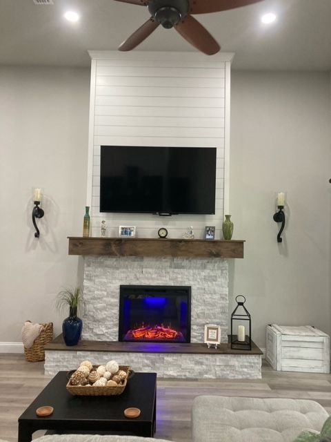 A living room with a fireplace and a flat screen tv