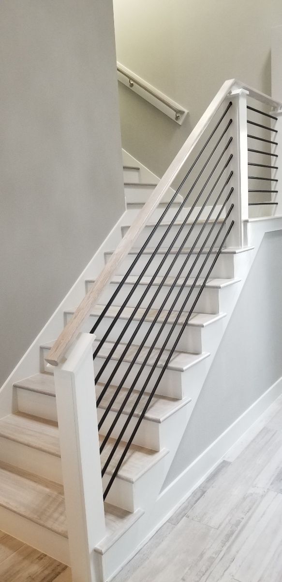A white staircase with a black railing in a house.