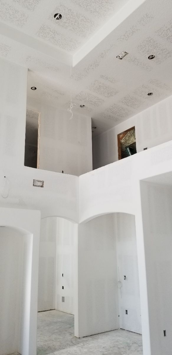 An empty room with a double ceiling and arches.