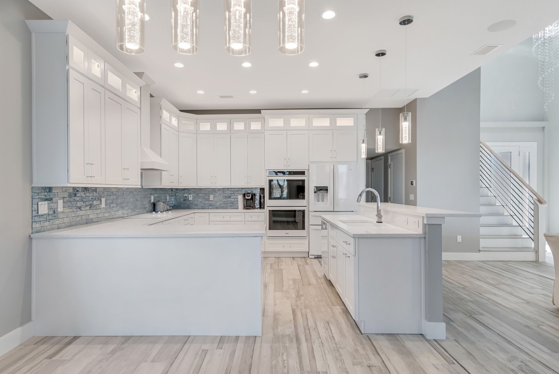A kitchen in a house with white cabinets and a large island.
