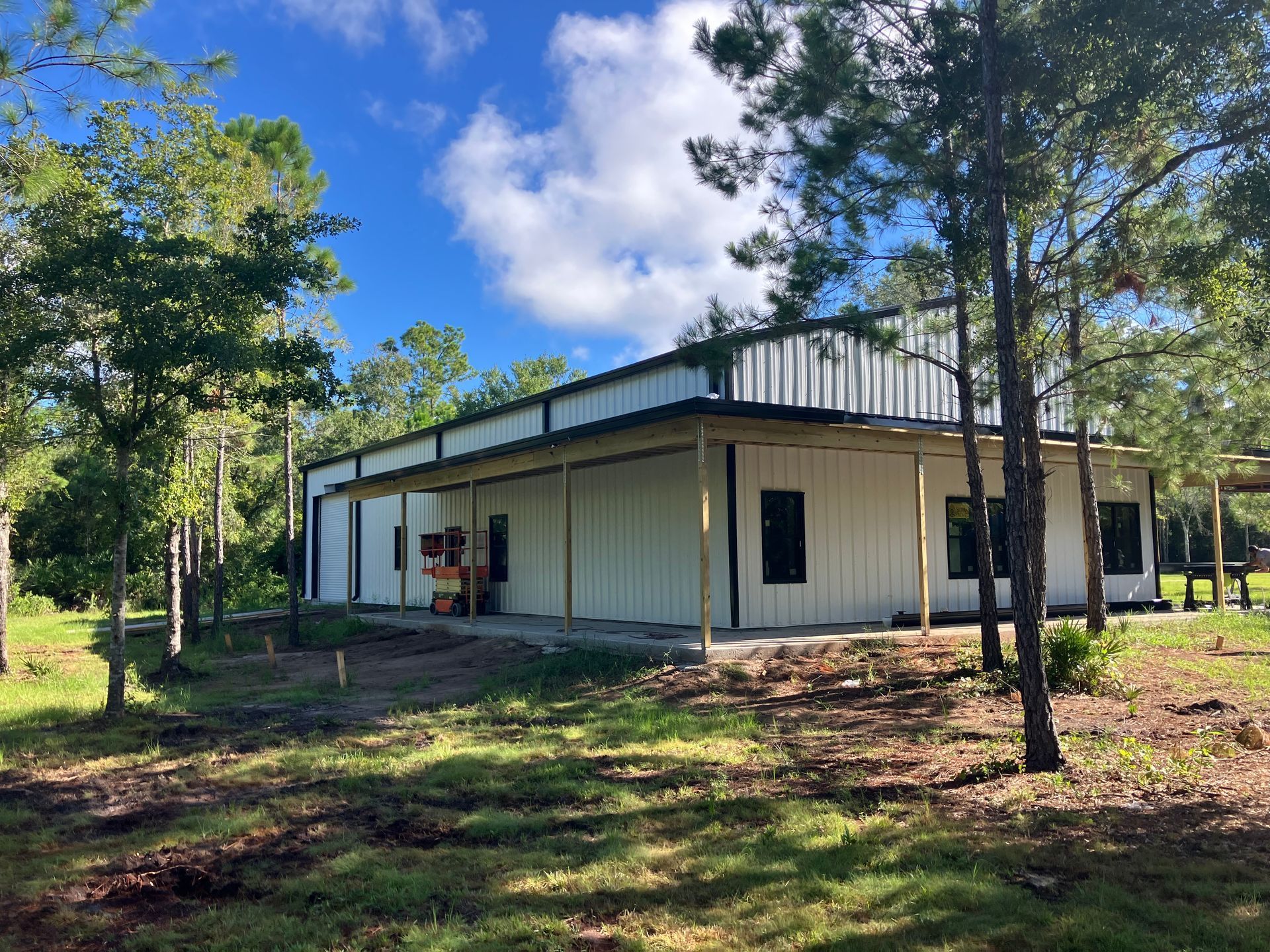 A large white building is surrounded by trees and grass