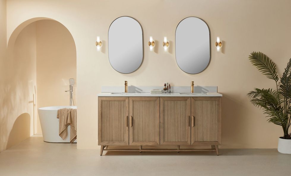 Bright minimalist bathroom with arched shower, double vanity, round mirrors, and warm beige tones