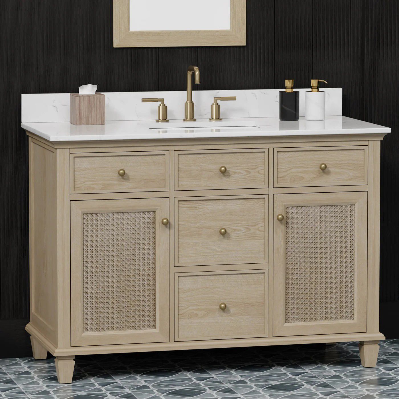 Beige double vanity with white countertop, gold faucets, and woven cabinet doors against a dark wall.