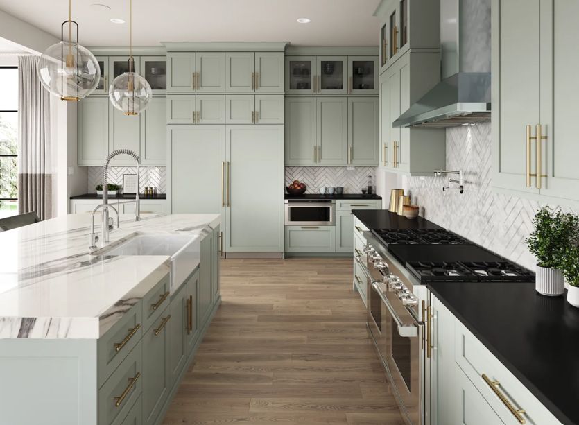 Bright modern kitchen with white cabinets, marble island, black countertops, and wood floors