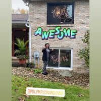 A woman is standing in front of a house 