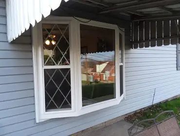 A white bay window on the side of a house.